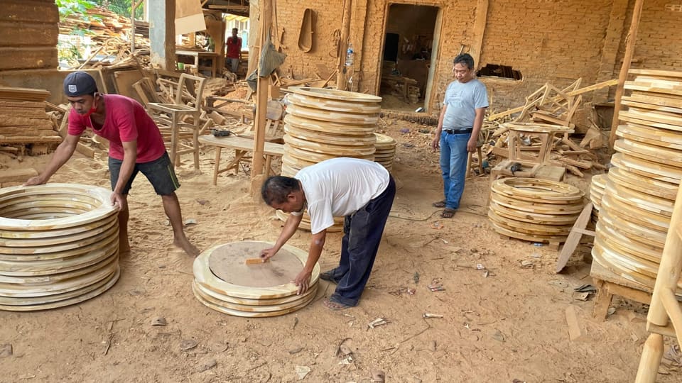 Stacks of round teak table tops in the joinery yard