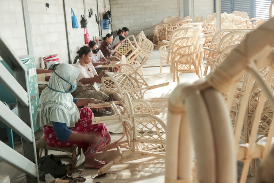 Weavers finishing rattan chair frames
